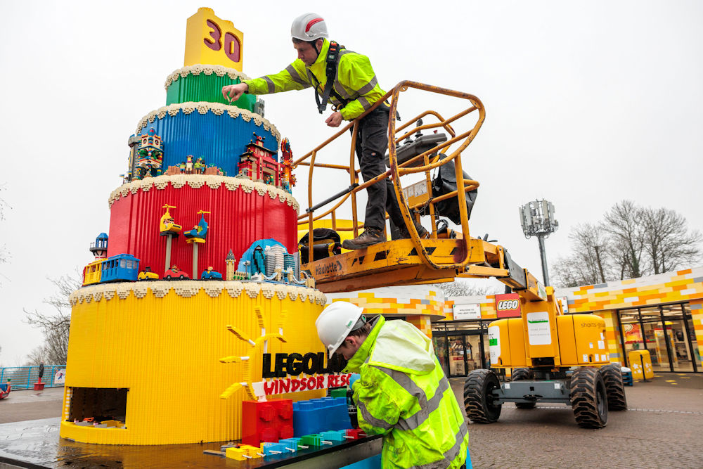 People adding bricks to the Legoland 30th birthday cake